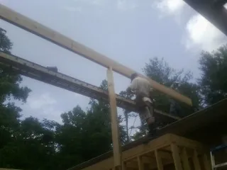 Carpenter setting a ridge beam over a new addition frame — Ice Dam Removal by Roofing Brothers in New Preston Marble Dale