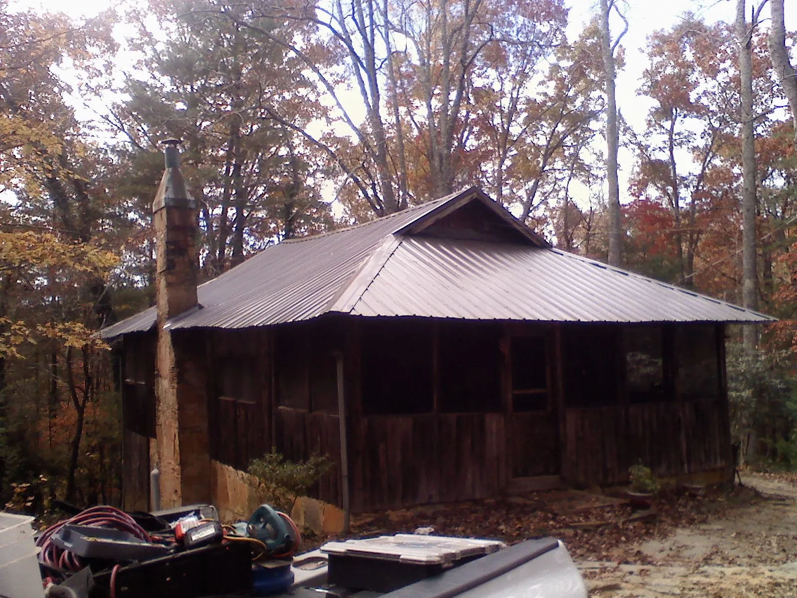 Brown metal hip roof on an old cabin with a stone chimney in New Preston Marble Dale