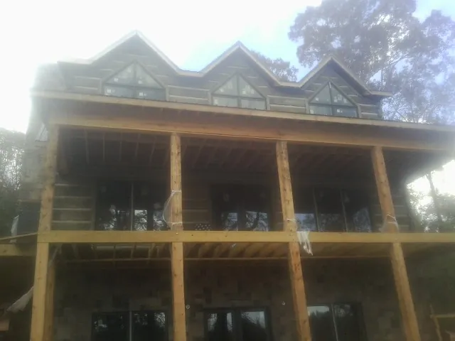 Dormers and porch framing on a large log home under construction — Roof Coating work by our crew in New Preston Marble Dale
