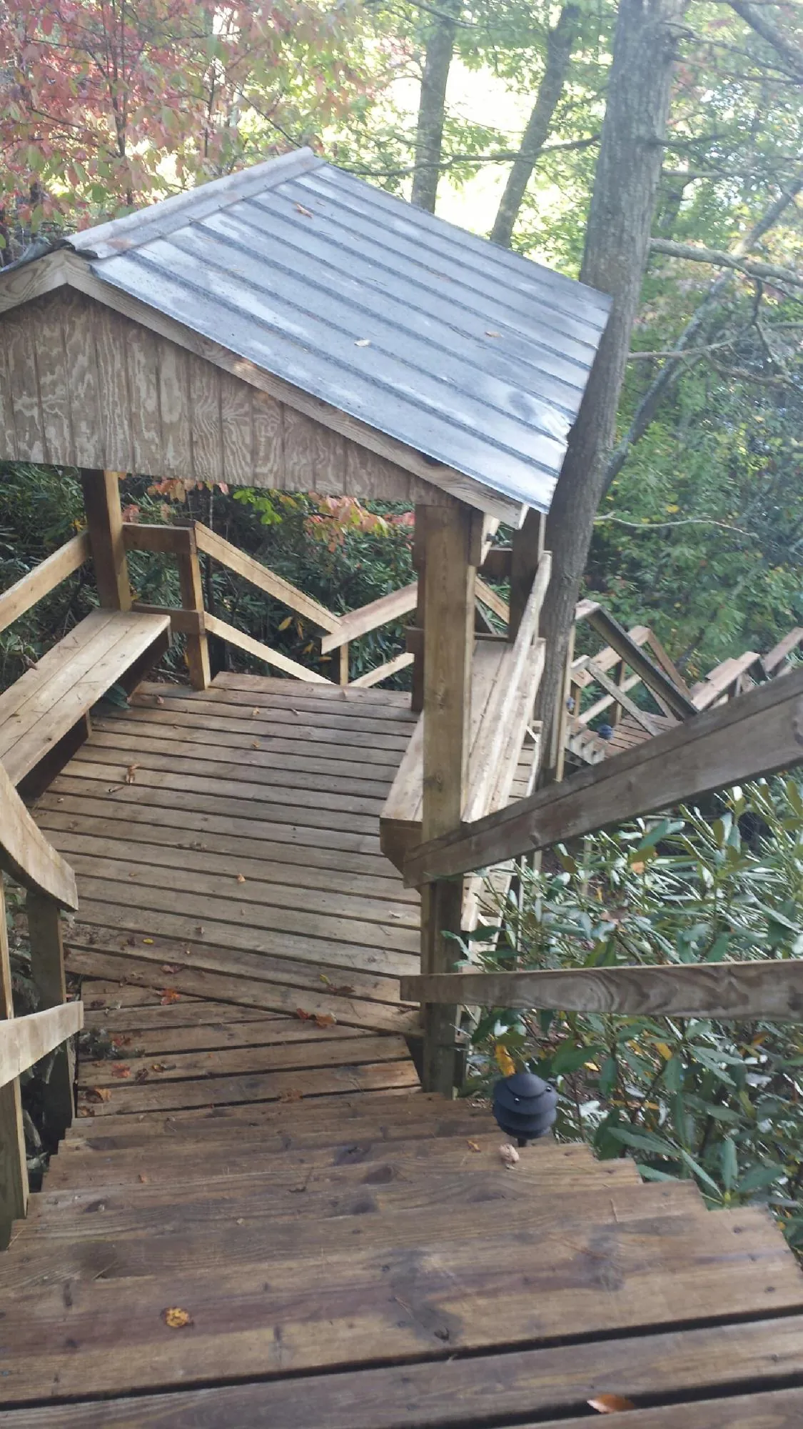 Metal roofed shelter over wooden steps on a wooded walkway — Skylight Repair & Installation work by our crew in New Preston Marble Dale